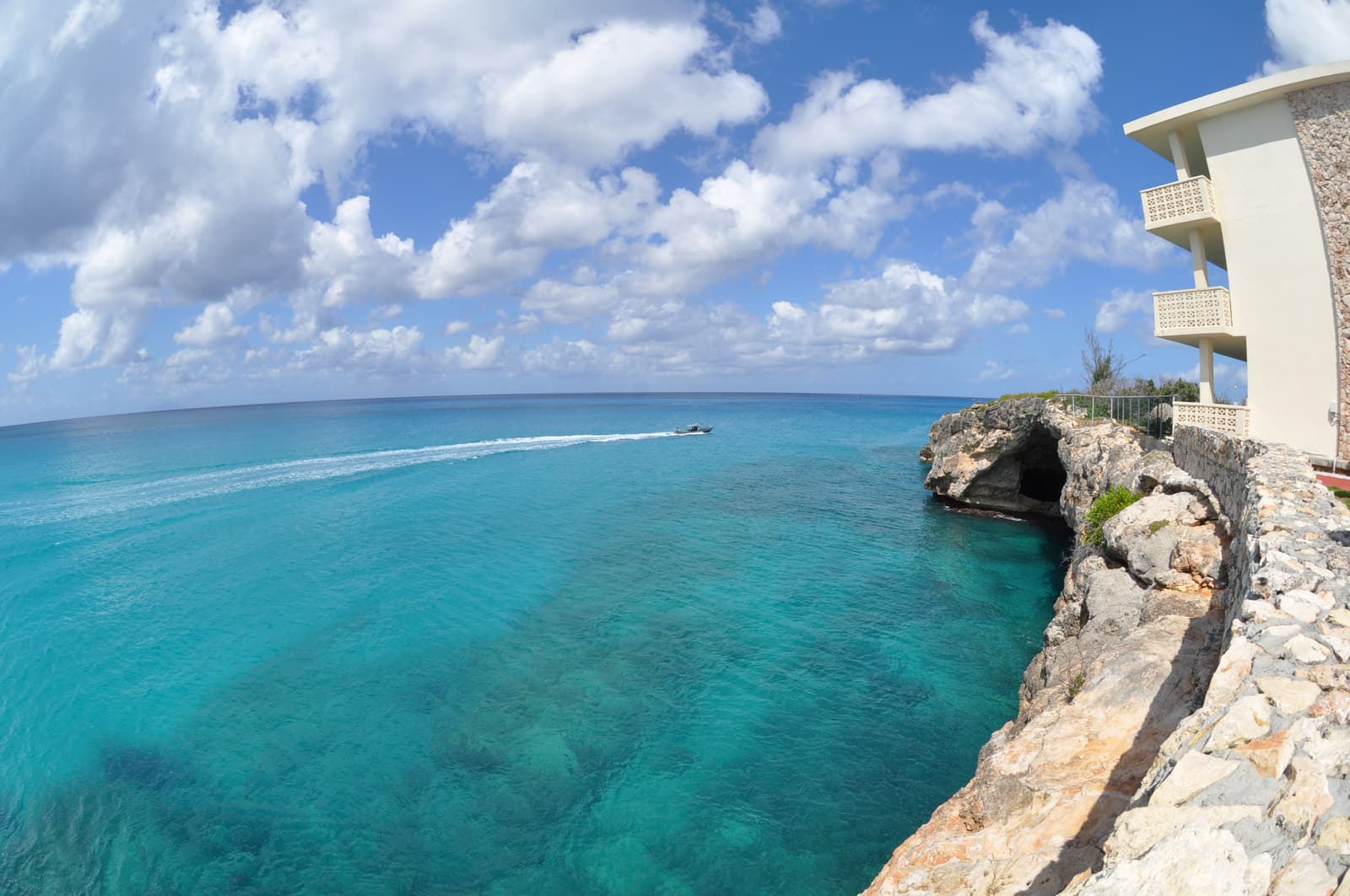Low cliffs with a sea cave above clear turquoise water near Cupecoy