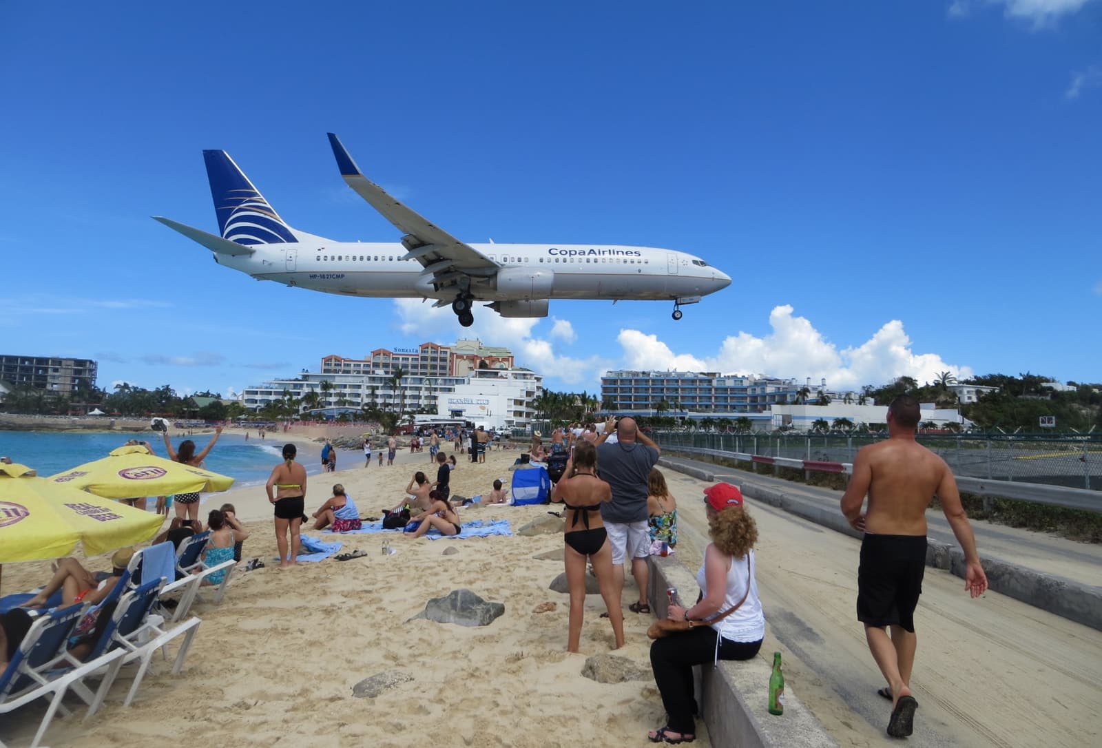 A jet airliner passing low over beachgoers at Maho Beach