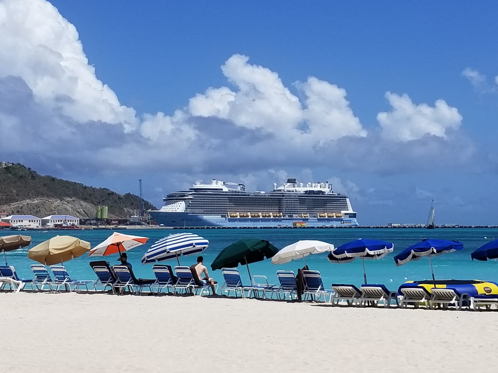 Parasols on Great Bay Beach in Philipsburg with a cruise ship at the pier behind