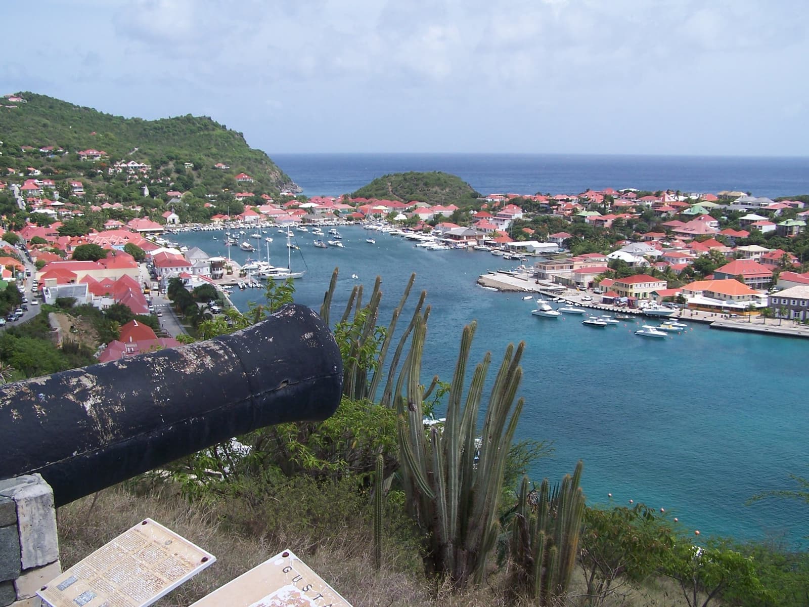 Gustavia harbour on St Barths seen from above, with an old cannon in the foreground