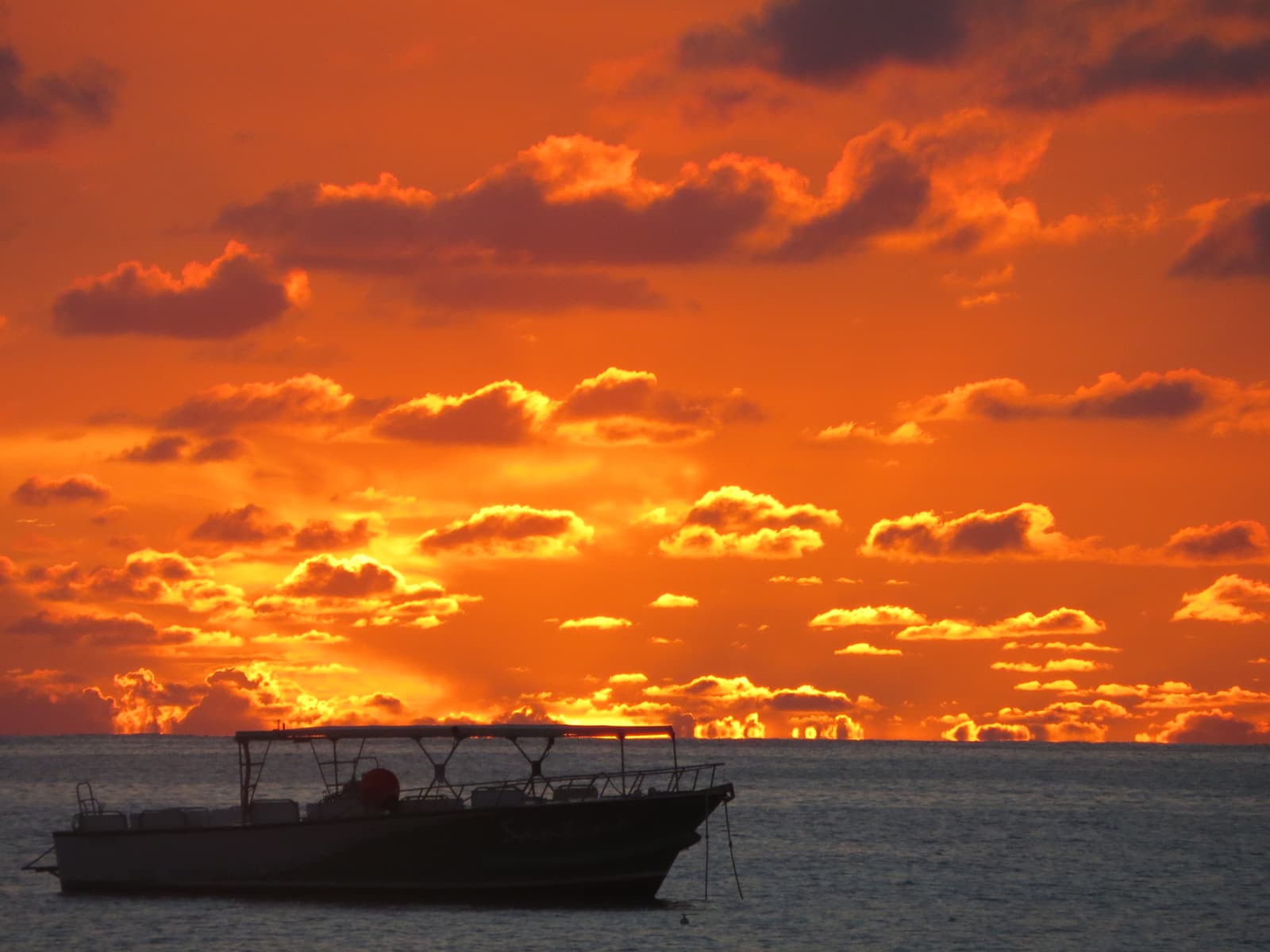 An orange sunset over the sea off Simpson Bay